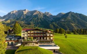 a large building with mountains in the background at Hotel Ennstalerhof in Ramsau am Dachstein