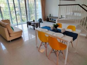 sala de estar con mesa blanca y sillas amarillas en Cyberia Crescent - 3 bedroom 8 Pax, en Cyberjaya
