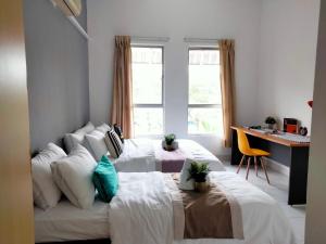 um quarto com 2 camas, uma secretária e uma janela em Cyberia Crescent - 3 bedroom 8 Pax em Cyberjaya