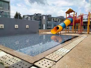 uma piscina com escorrega e um parque infantil em Cyberia Crescent - 3 bedroom 8 Pax em Cyberjaya