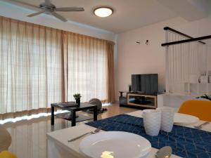 uma sala de estar com uma mesa e uma televisão em Cyberia Crescent - 3 bedroom 8 Pax em Cyberjaya