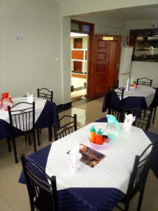 a dining room with blue and white tables and chairs at Sai Inn Eldoret in Eldoret