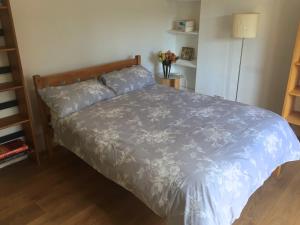 Schlafzimmer mit einem Bett mit blauer Decke in der Unterkunft Kensington flat with roof terrace and sunshine in London