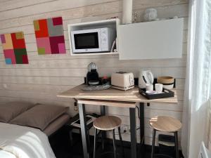 een kamer met een tafel met een magnetron en een bed bij Chambre d’hotes golf du Morbihan in Plougoumelen