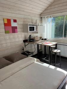 1 dormitorio con cama, mesa y microondas en Chambre d’hotes golf du Morbihan, en Plougoumelen