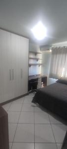 een slaapkamer met een bed en een bureau. bij Aconchego in Chapecó