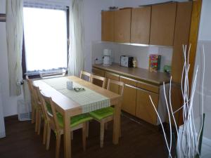 a kitchen with a table and chairs and a table and a window at Jüttis in Wimbach