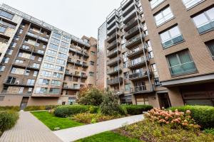 un complejo de apartamentos con edificios altos y un jardín en Qbik Artistic Cityscape Apartment, en Varsovia