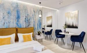 布加勒斯特Government Deluxe Studio by Magic Apartments的一间卧室，里面有一张床、一张桌子和几把椅子。