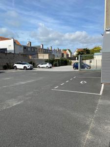 een lege parkeerplaats met twee auto's erin geparkeerd bij Hôtel De Wimereux in Wimereux
