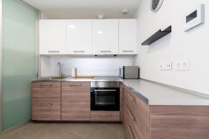 kuchnia z białymi szafkami i czarnym piekarnikiem w obiekcie Veoapartment Rastro w Sewilli