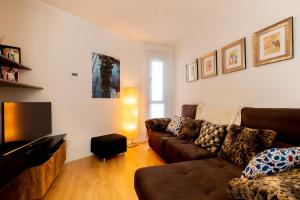 salon z kanapą i telewizorem w obiekcie Veoapartment Rastro w Sewilli