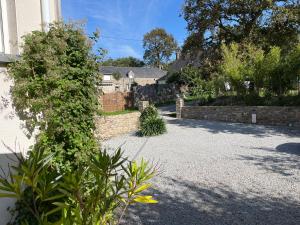 una casa con una valla de piedra y un patio en Chambre d’hotes golf du Morbihan, en Plougoumelen