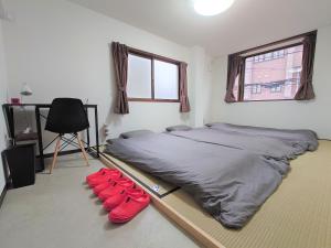 a bedroom with a bed with red pillows on the floor at Stay Inn KOTO in Kyoto