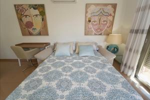 um quarto com uma cama, uma mesa e pinturas em El Balcon Deluxe em Baena