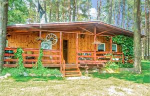 een blokhut in het bos met een veranda en een trap bij Nice Home In Ostrda With Kitchen in Ostróda