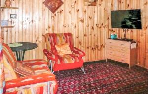 オストルダにあるNice Home In Ostrda With 3 Bedroomsのリビングルーム(テレビ、椅子、テーブル付)
