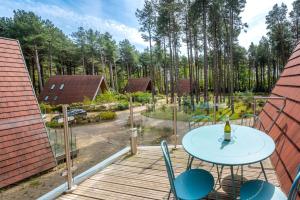 a patio with a table and chairs on a deck at Liz's Lodge by Big Skies Cottages in Weybourne