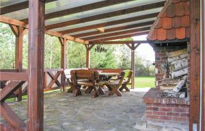 a wooden pavilion with a table and chairs on a patio at 3 Bedroom Amazing Home In Jedwabno in Jedwabno