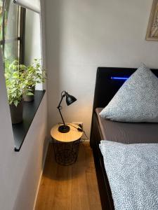 a bedroom with a bed and a lamp on a table at City Park Loft in Münchberg