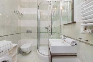 a bathroom with a shower and a toilet and a sink at Apartamenty Zatoka Górny Sopot in Sopot