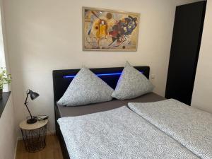 um quarto com uma cama com almofadas e um quadro em City Park Loft em Münchberg