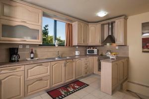 a kitchen with wooden cabinets and a window at Villa La Palma in Vrísai
