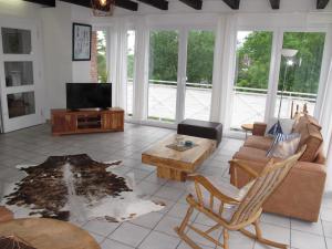 ein Wohnzimmer mit einem Sofa und einem TV in der Unterkunft FeWo UKENA DORN204 in Dornum