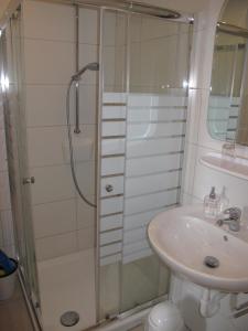 ein Bad mit einer Dusche und einem Waschbecken in der Unterkunft FeWo UKENA DORN204 in Dornum