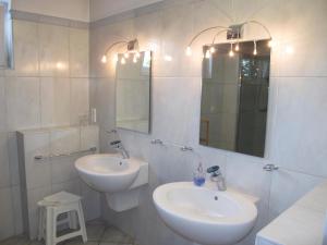 Baño blanco con 2 lavabos y espejo en FeWo UKENA DORN204, en Dornum
