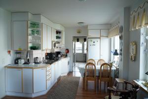 - une cuisine avec des placards blancs, une table et des chaises dans l'établissement Brahenkatu Apartment, à Kajaani