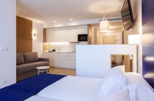 a bedroom with a white bed and a couch at Apartamentos Mayal con Piscina in Benidorm