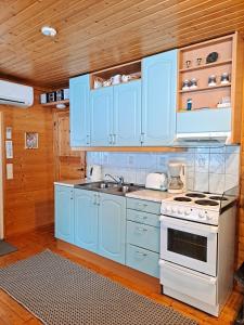 a kitchen with blue cabinets and a stove at Pikkuturska in Kalajoki