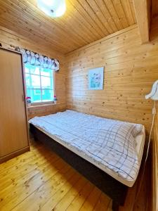 a bedroom with a bed in a wooden room at Pikkuturska in Kalajoki