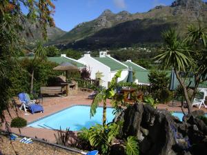 a swimming pool with a mountain in the background at Birdsnest Guest Accommodation in Hout Bay