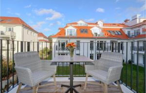 two chairs and a table with a vase of flowers on a balcony at Baltischer Hof Apartment 32 in Boltenhagen