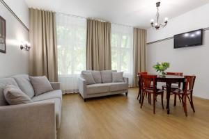 a living room with a couch and a table and chairs at Koidulapark Hotell in Pärnu