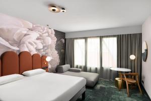 a hotel room with two beds and a mural at Mercure Debrecen in Debrecen