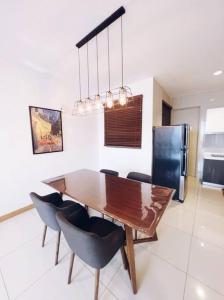 a kitchen and dining room with a wooden table and chairs at [PROMO]Connected train 2 Bedrooms - Above Mall(25) in Kuala Lumpur