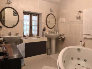 a bathroom with a tub and a sink and a bath tub at Gite Belle Vue in Visan