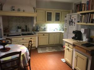 a kitchen with white cabinets and a table in it at Gite Belle Vue in Visan