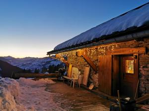 a cabin with a deck with christmas lights on it at Maison de 5 chambres avec jardin amenage et wifi a Seez a 7 km des pistes in Séez