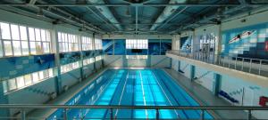 a large indoor swimming pool with blue water at Arena Hotel Balakan in Balakǝn