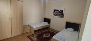 a small room with two beds and a rug at Arena Hotel Balakan in Balakǝn +22 photos
