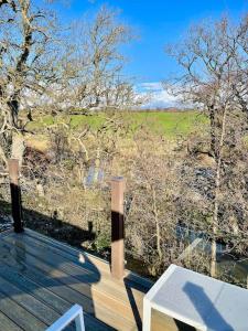 a balcony with a table and a view of a field at Unwind@36 Lodge in Felton