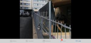 a fence with a sign on it next to a building at Brahenkatu Apartment in Kajaani