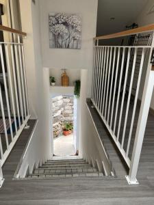 a staircase in a home with white railings at Lovely newly refurbished, 1 bedroom top floor apartment with sea views, fast WI-FI CABLE TV and Netflix in Ribeira Brava