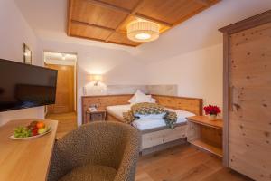 a bedroom with a bed and a table with chairs at Hotel Olympia in Ischgl