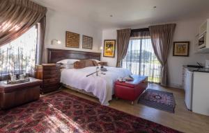 a bedroom with a bed and a large window at Cape Pillars Boutique Hotel in Durbanville