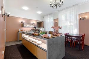 a kitchen with a counter with a table and chairs at Koidulapark Hotell in Pärnu